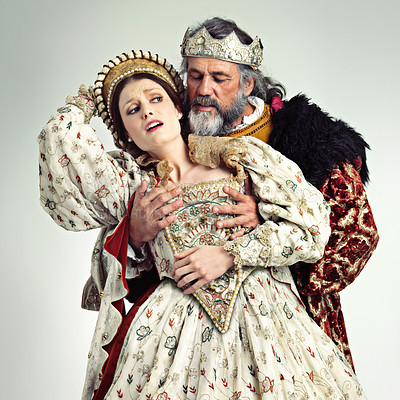 Buy stock photo Theater, king and queen in costume with violence in in crown and renaissance clothes in studio. Art, cosplay and larp, couple in medieval play, royal history character and woman in distress with man.