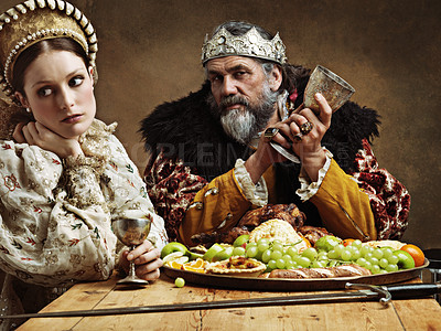 Buy stock photo King, queen and portrait with feast at table for fine dinning in royal banquet, vintage and majestic with crown. Monarch, husband and bored together with alcohol for buffet for formal celebration.