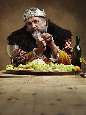 Buy stock photo Portrait, king and feast in table with wine as royalty on dining hall for tradition, culture and meal in palace. Confident, monarch and leader with eating buffet or supper as lord with crown