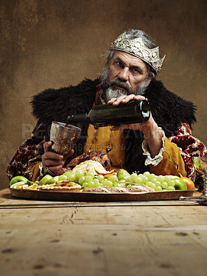Buy stock photo King, royal and feast in table with wine as lord on dining hall for tradition, culture and meal in palace. Portrait, monarch and food with man eating buffet or supper with confidence and crown