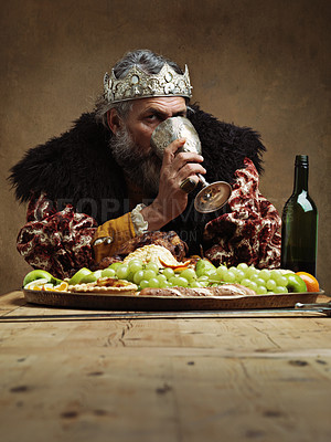 Buy stock photo King, feast and drink wine in table as royalty on dining hall for tradition, culture and meal in palace. Portrait, monarch and leader with eating buffet or supper with chicken in confidence and crown