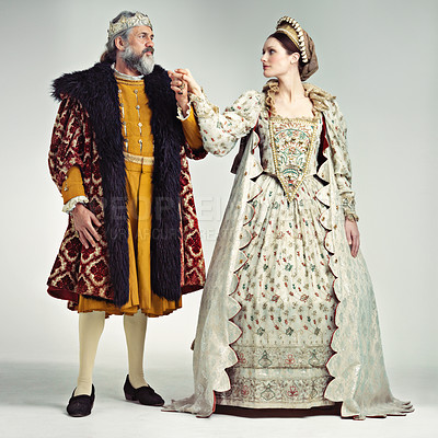 Buy stock photo Studio portrait of a king and queen standing hand in hand