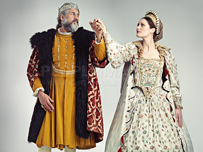 Buy stock photo Medieval, love and king with queen in studio on gray background for power, ruler and leadership. History, theatre and isolated royal couple holding hands in vintage, renaissance and Victorian cosplay
