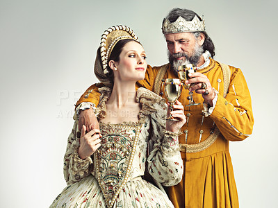Buy stock photo Studio shot of a king and queen drinking out of goblets