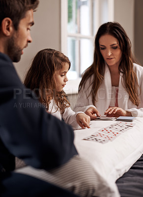 Buy stock photo Mom, dad and girl with playing cards in home with bonding, learning and relax with strategy in bedroom. Father, mother and daughter with deal, game and teaching on bed with connection in family house