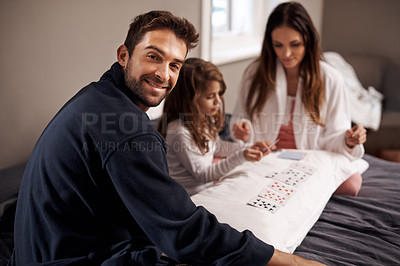 Buy stock photo Parents, girl and playing cards for portrait in home with bonding, learning or happy for strategy in bedroom. Dad, mother and daughter with deal, deck and child on bed with connection in family house