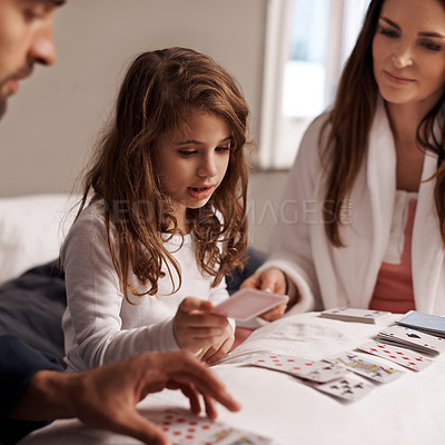Buy stock photo Parents, girl and fun of playing cards in home for bonding, learning and relax with strategy in bedroom. Father, mother and daughter with games, maths and teaching with connection in family house