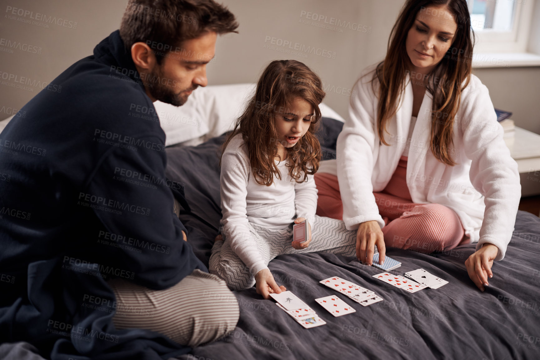 Buy stock photo Mom, dad and girl with playing cards to relax in home with bonding, learning or fun with strategy in bedroom. Father, mother and daughter with games, maths or teaching with connection in family house