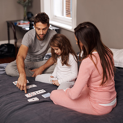 Buy stock photo Parents, girl and playing cards to relax for fun with bonding, learning and games with strategy in home bedroom. Father, mother and daughter on bed, maths and teaching with connection in family house