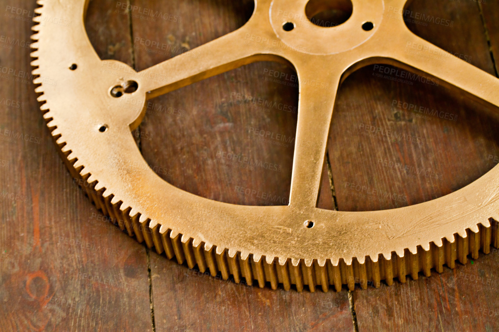 Buy stock photo Clock gear, gold and wheel cog on a wood table with golden machinery and gears. Metal, closeup and steel with machine detail and maintenance on wooden tabletop with brass parts and wheels on surface