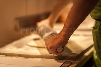 Buy stock photo Cropped shot of a person rolling out pizza dough