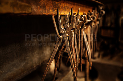 Buy stock photo A range of pliers and tongs hanging in a workshop