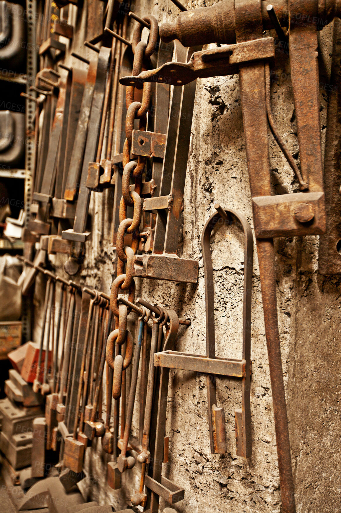 Buy stock photo Steel, tools and workshop with blacksmith workplace and industrial factory wall background. Artisan, retro and metal tool for manufacturing, warehouse and brass forge industry equipment hanging