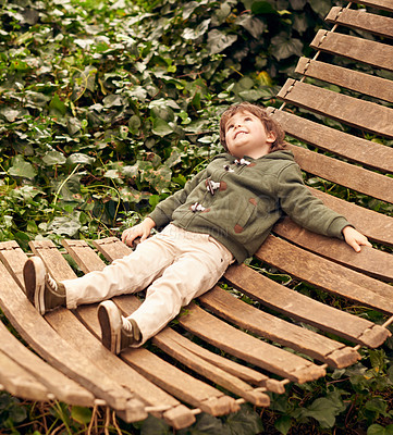 Buy stock photo A little boy relaxing in a hammock in his backyard