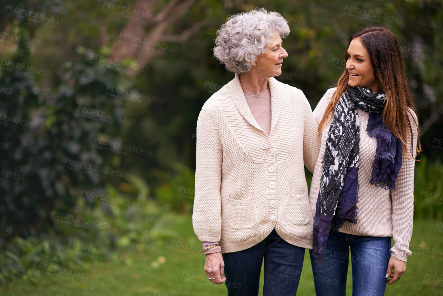 Buy stock photo Shot of an attractive woman spending time with her senior mother outdoors