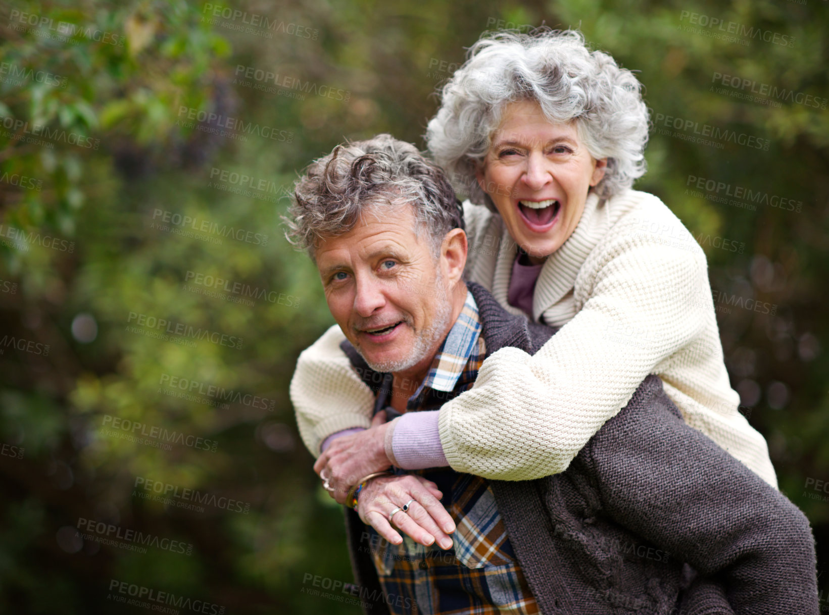 Buy stock photo Shot of a loving senior couple being playful outside