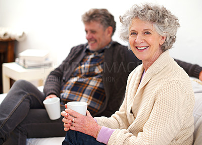 Buy stock photo Portrait of a senior couple relaxing in their living room with coffee