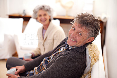 Buy stock photo Portrait of a loving senior couple sitting together in their lounge