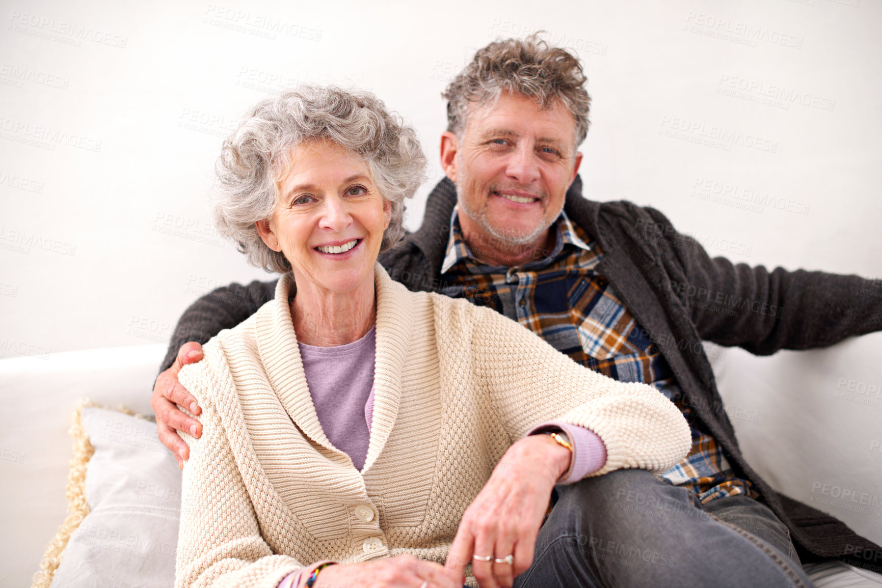 Buy stock photo Portrait of a loving senior couple sitting together on a sofa