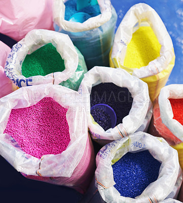 Buy stock photo Bag, color and plastic resin with polymer for dye, manufacturing and ecology on floor in factory. PVC pellets, industry and molecule in recycling plant for storage, particle and above in warehouse