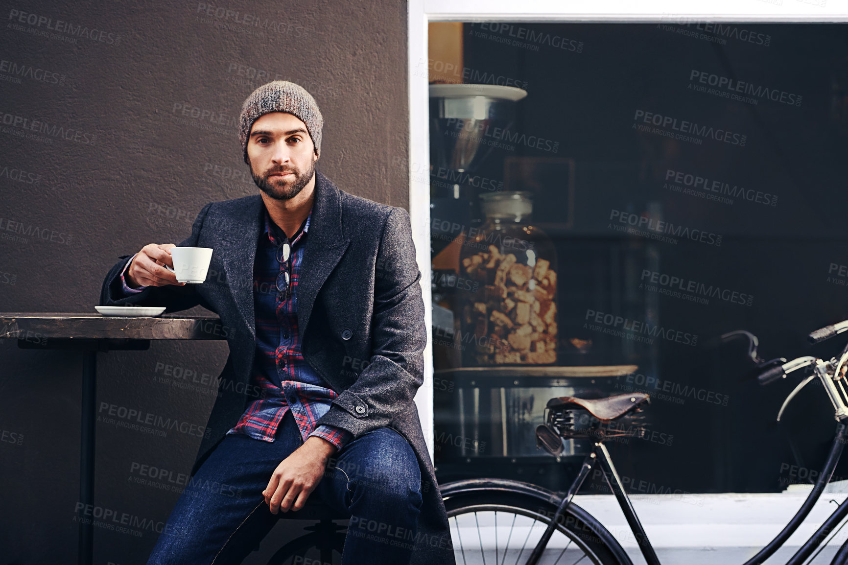 Buy stock photo Portrait, city and man drinking coffee with bicycle at cafe table for breakfast in the morning. Bike, tea cup and serious person with espresso, latte or beverage at restaurant with winter fashion