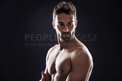Buy stock photo Studio shot of a handsome man standing shirtless against a black background