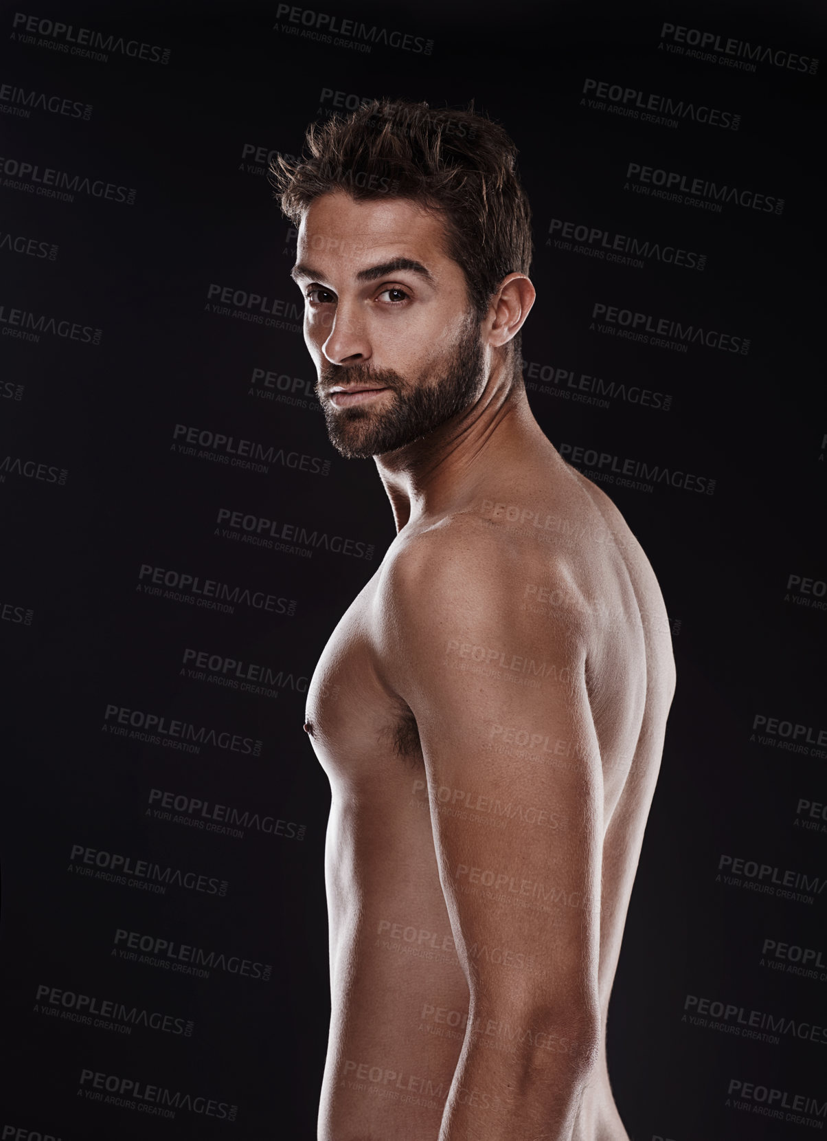 Buy stock photo Portrait of a handsome man standing shirtless against a black background