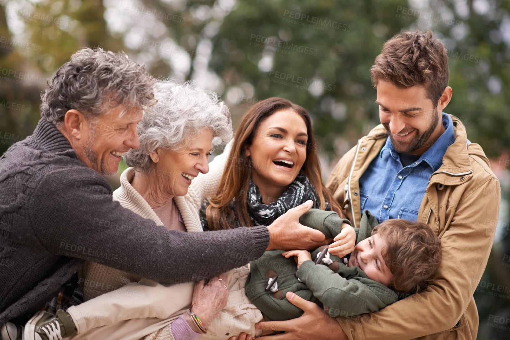 Buy stock photo Happy family, child and people playing with kid in a park on outdoor vacation, holiday and excited together. Grandparents, happiness and parents play with kid as love, care and bonding in nature
