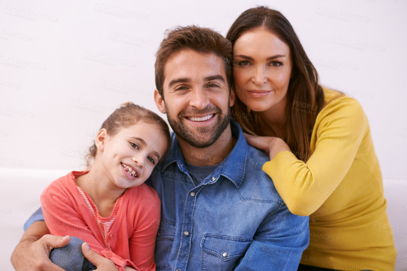 Buy stock photo Portrait of a happy young family sitting together at home