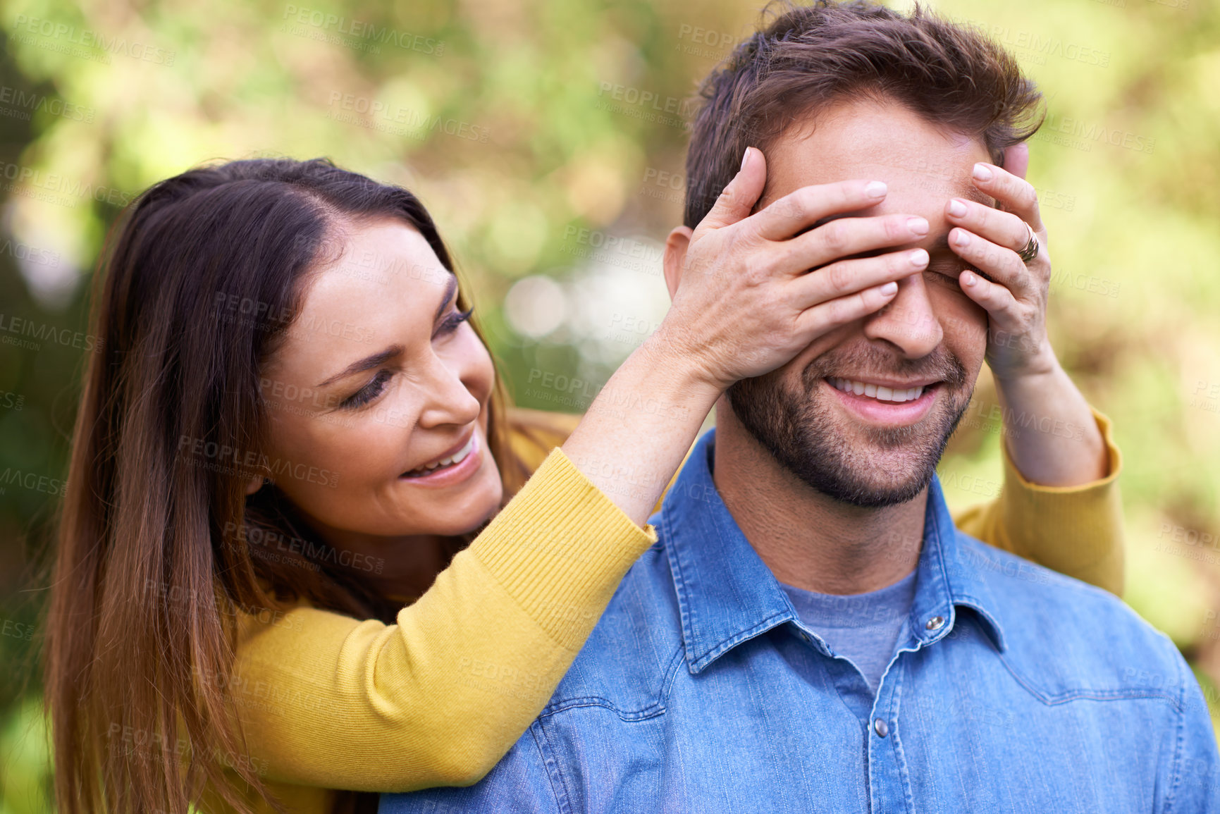 Buy stock photo Shot of a happy young couple being playful outside