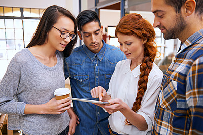 Buy stock photo Shot of a designer with a tablet sharing her ideas with her colleagues