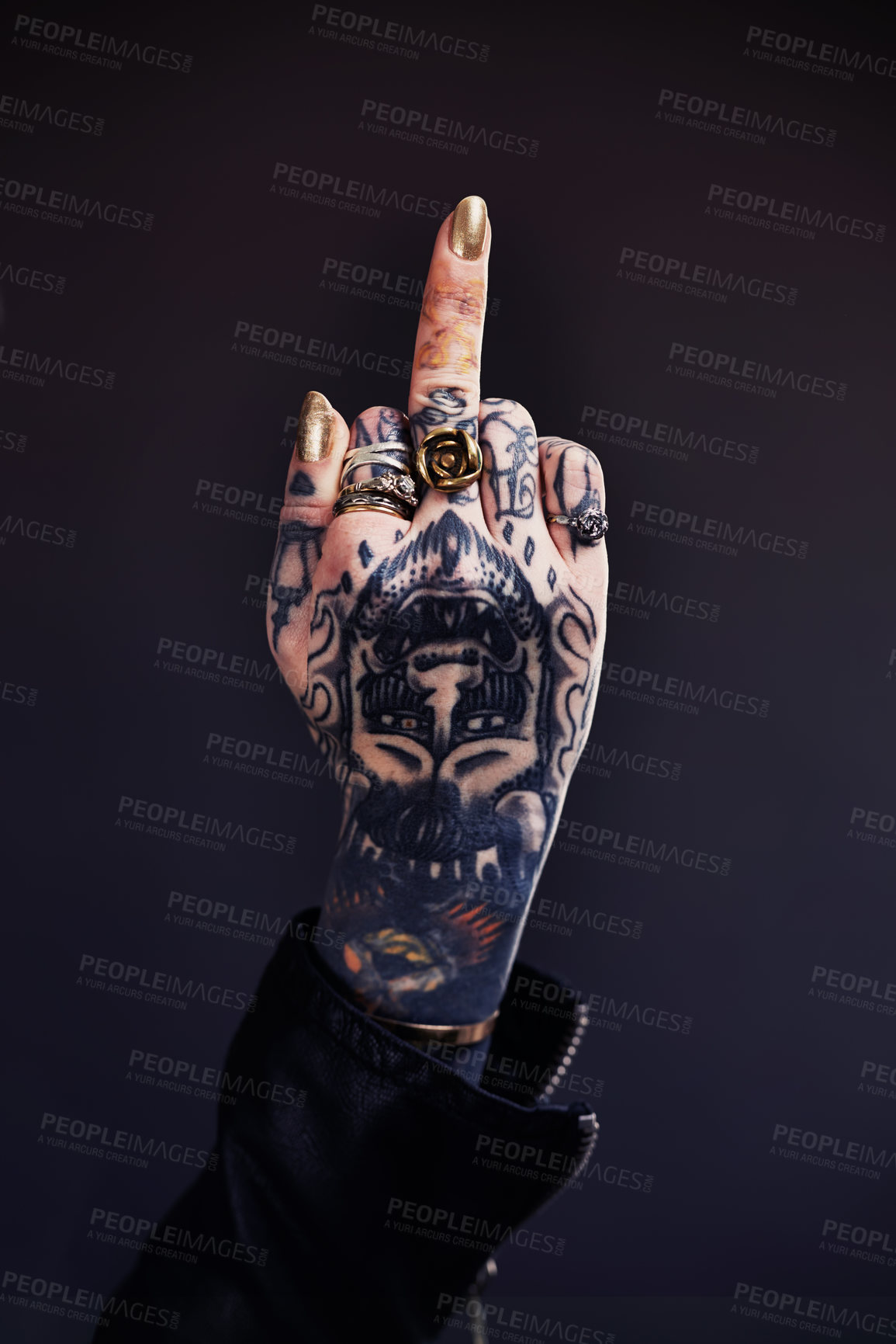 Buy stock photo Shot of a tattooed woman giving the finger to the camera