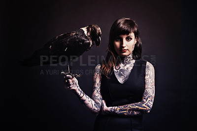 Buy stock photo Fashion, woman and portrait with bird in studio for witchcraft or magic, mysterious and fantasy with punk tattoo. Person, eagle and isolated on black background for darkness and creepy grunge look.