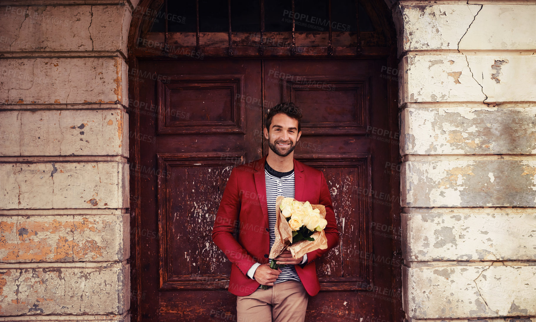 Buy stock photo Shot of a handsome young urban man holding a bunch of flowers