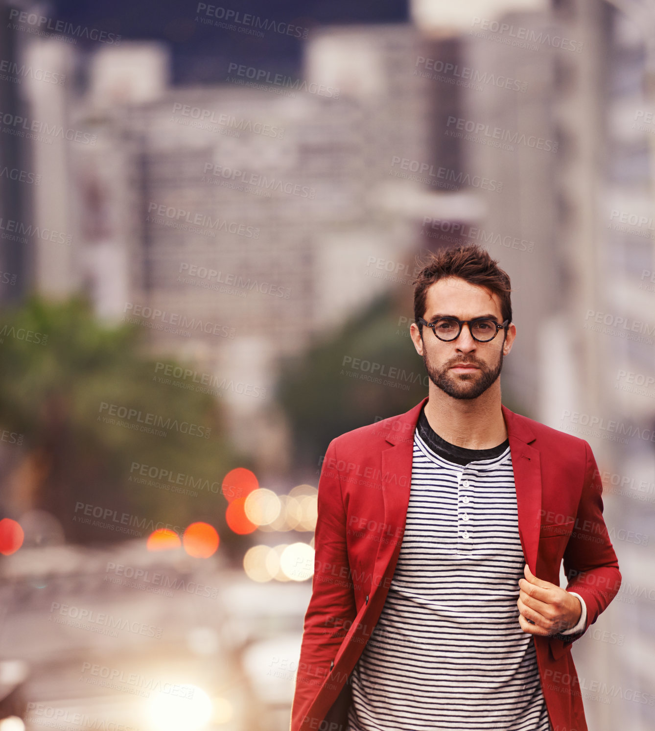 Buy stock photo Shot of a handsome young man taking a walk through the city