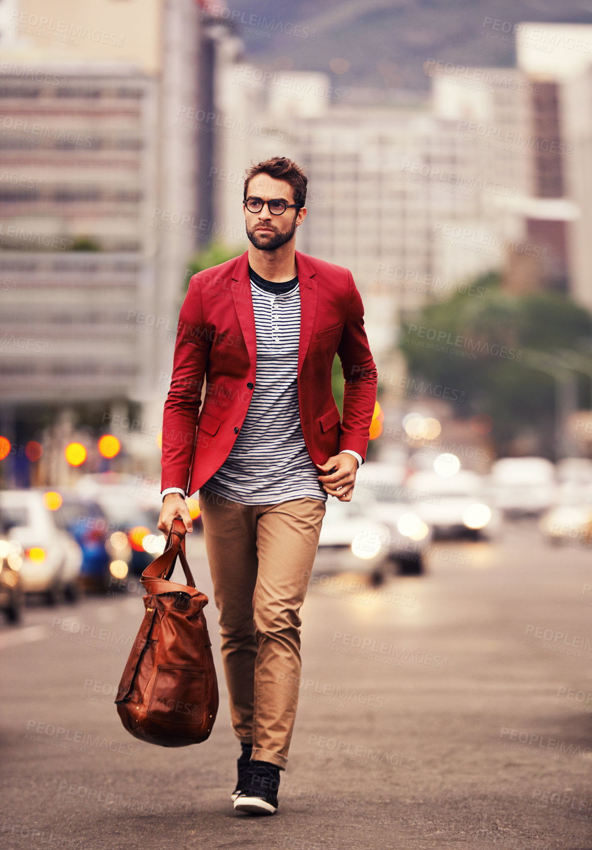 Buy stock photo Shot of a handsome young man taking a walk through the city