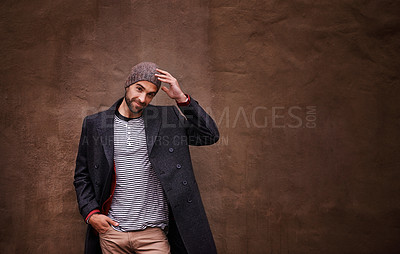 Buy stock photo Man, confidence and smile with urban, fashion and trendy gentleman jacket. Model, winter and beanie with city, happiness or outdoor positivity for cool hipster style isolated on brown wall background