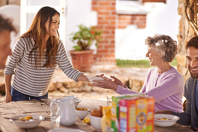 Buy stock photo Family, eating and happy in garden for breakfast with serve, hosting and bonding for nutrition or wellness. Senior, women and relax together in backyard or patio in morning with healthy meal or food 