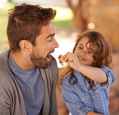 Buy stock photo Happy father, food and girl feeding in morning on bench with family for breakfast, nutrition and happiness. Dad, child and meal outdoors for food, health and sharing with open mouth, smile and joy.