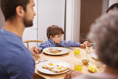 Buy stock photo Home, family and praying for breakfast, holding hands and table in kitchen with father, son and religion. House, boy and man worship for eating, bread and juice for diet, healthy and gratitude