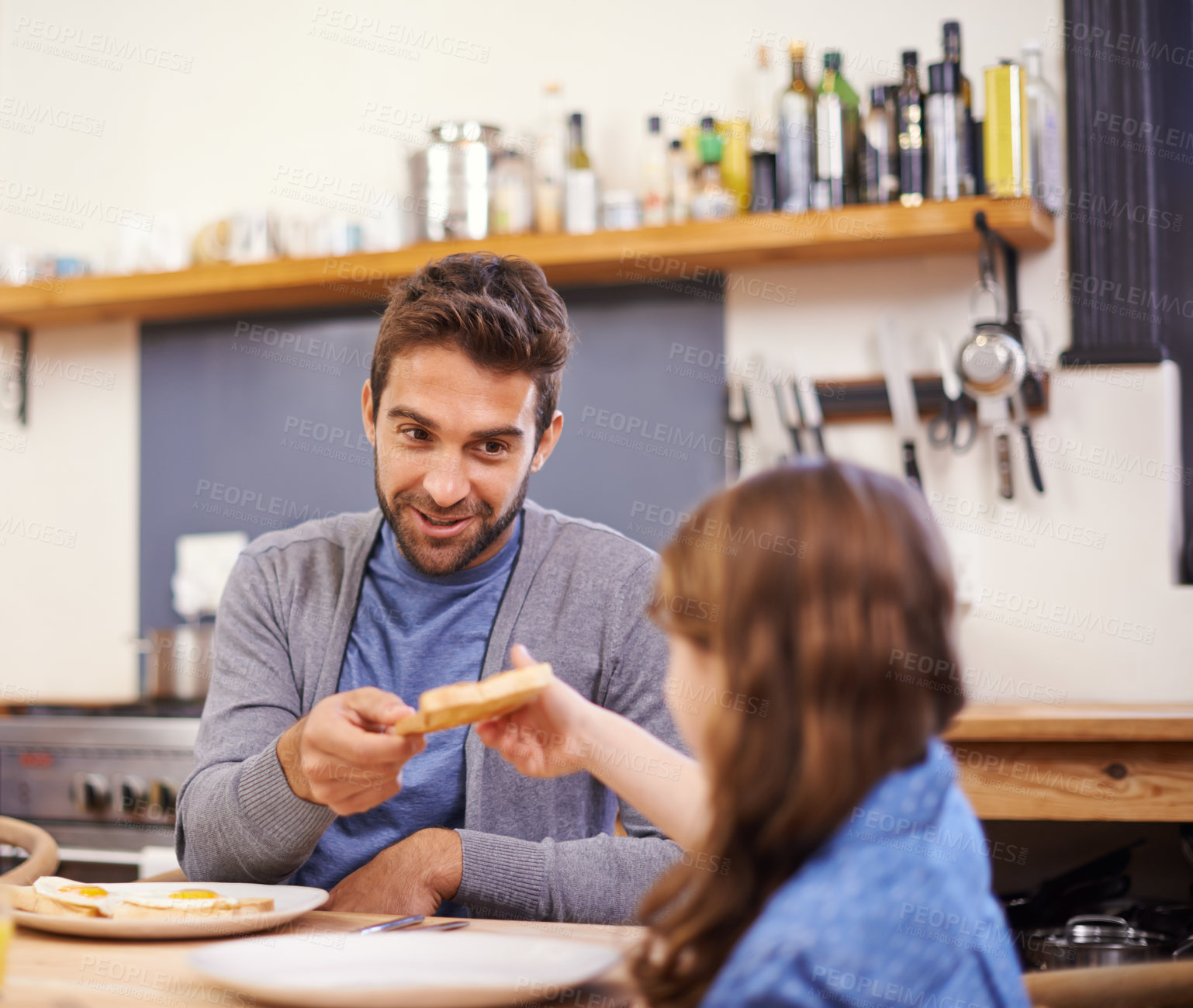 Buy stock photo Shot of a little girl eating breakfast with her dad in the kitchen