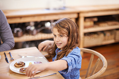Buy stock photo Girl child, breakfast and pancakes in house with table, smile and family for wellness, health and energy. Female kid, food and happy in home together with parent for nutrition, eating and strength. 