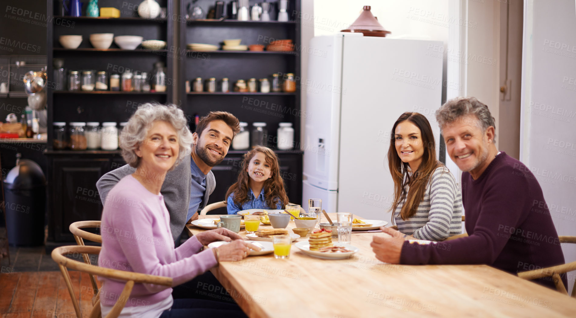 Buy stock photo Portrait of a family eating breakfast around the kitchen table