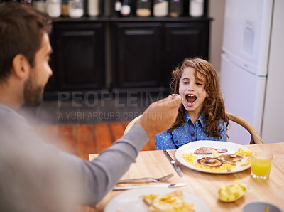 Buy stock photo Dad, feeding and girl eating breakfast on table at home kitchen for health, nutrition and wellness. Child, father and happy for food in family house together for morning meal, development and diet