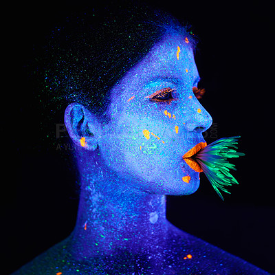 Buy stock photo Neon, paint and creative woman in studio with plant for organic art, psychedelic aesthetic or cosmetics. Glow makeup, person or fluorescent glitter for uv illusion or fantasy glow on black background