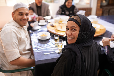Buy stock photo Portrait of a muslim woman looking back while enjoying a feast with her family