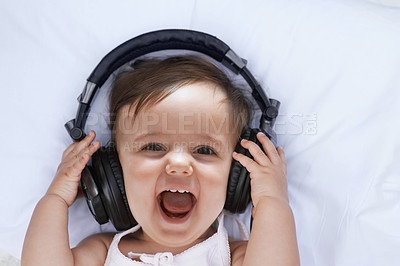 Buy stock photo Baby, headphones and music in portrait and singing, streaming radio and podcast on bed at home. Girl, relax and hearing audio for child development or learning, toddler and fun playlist for kid