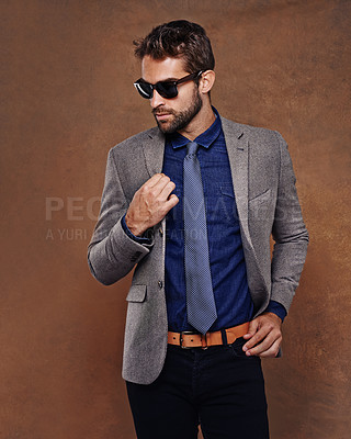 Buy stock photo Confident, sunglass fashion and male model in studio for corporate trends on brown background for businessman aesthetic. Professional style, trendy and man with confidence in office workwear. 