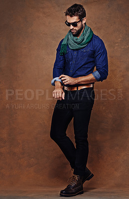 Buy stock photo Fashion, confidence and man or model in studio isolated on a brown background mockup space. Serious, person and roll sleeve on shirt for style in casual clothes, trendy or cool sunglasses with jeans