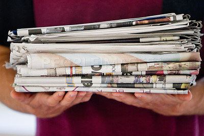 Buy stock photo Cropped shot of a person holding newspapers for recycling